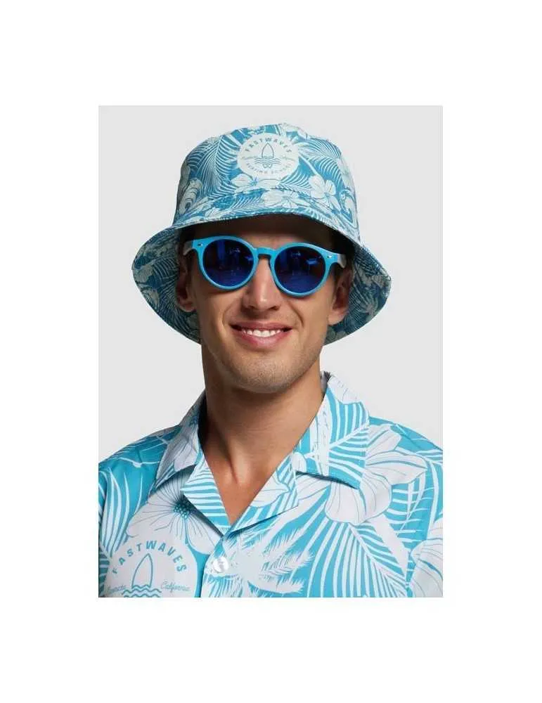 Un jeune homme avec une chemise à fleurs bleu et une lunette de soleil bleu ainsi qu'un bob personnalisé avec des feuilles bleu